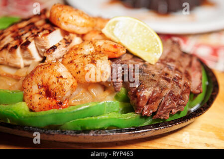 Fajitas in Metall pan auf Holzbrett, flacher Fokus Stockfoto