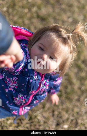 Süße 17-Monate altes Baby Mädchen spielen mit Ihrem Vater. Outdoor und Leiter Fotografie Stockfoto