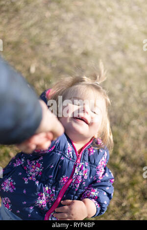 Süße 17-Monate altes Baby Mädchen spielen mit Ihrem Vater. Outdoor und Leiter Fotografie Stockfoto