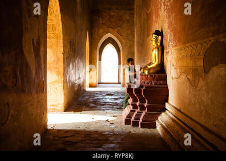 Ein Mann sagt, ein Gebet zu einer goldenen Buddha im Inneren Sulamani Pahto Tempel in Bagan Stockfoto