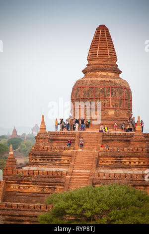 Touristen klettern auf einen Tempel den Sonnenaufgang in Bagan, Myanmar zu beobachten Stockfoto