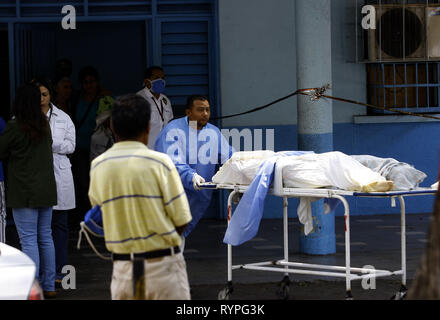 Valencia, Carabobo, Venezuela. 14 Mär, 2019. März 14, 2019. Personal der Bahre führen Sie die Übertragung von zwei Leichen aus der Not und Hospitalisierung Bereich in die Leichenhalle des gleichen Enrique Tejera Central Hospital, Stunden vor dem Besuch der Menschenrechtskommission der Vereinten Nationen unter der Leitung des ehemaligen chilenischen Präsidentin Michelle Bachelet. Ärzte, Angehörige der Patienten und ihrer eigenen Patienten berichtet, dass viele Patienten sterben, wenn sie nicht ausreichende Behandlung aufgrund eines Mangels an Medikamenten, Nahrungsmitteln, Wasser und sogar mangelnde Sauberkeit in der facilitie erhalten Stockfoto