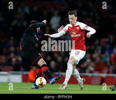 London, Großbritannien. 14 Mär, 2019. Mesut Ozil (R) von Arsenal ist von Clement Grenier von Rennes in der Europa League Runde 16 zweite Bein Spiel zwischen Arsenal und Rennes verschmutzt ist im Emirates Stadium in London, Großbritannien, am 14. März 2019. Arsenal besiegte Rennes mit 3-0 am Donnerstag (4-3 am Aggregat) und war für die Europa League qualifiziert - Finale. Quelle: Matthew Impey/Xinhua/Alamy leben Nachrichten Stockfoto