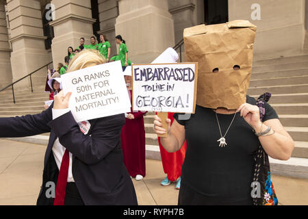 Atlanta, Georgia, USA. 14 Mär, 2019. Dutzende von pro-choice-Demonstranten, die gegen die "heartbeat Bill '' Rechtsvorschriften an der Georgia State Capitol Building gezeigt. Die Rechtsvorschriften würden die meisten Abtreibungen verbieten Nach sechs Wochen. Der Protest wurde von mehreren Gruppen einschließlich der Mägde Unite - Georgien organisiert. Mehrere Demonstranten als Zeichen aus dem Buch die Geschichte der Dienerin gekleidet. Quelle: Steve Eberhardt/ZUMA Draht/Alamy leben Nachrichten Stockfoto