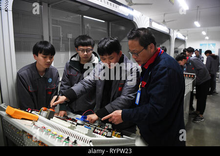 Chongqing, China. 14 Mär, 2019. Ein Student aus einer beruflichen Bildung Schule Praxis Industrieroboter, Anwendung und Wartung im yongchuan Bezirk von Chongqing, im Südwesten von China, 14. März 2019. Die lokalen Behörden bei der Verbesserung der beruflichen Bildung auf die Bedürfnisse des Arbeitsmarktes in den letzten Jahren gerecht zu werden. Credit: Wang Quanchao/Xinhua/Alamy leben Nachrichten Stockfoto