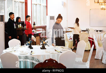 Chongqing, China. 14 Mär, 2019. Studenten der Hotel Management major aus einer beruflichen Bildung Schule Praxis Catering Service im yongchuan Bezirk von Chongqing, im Südwesten von China, 14. März 2019. Die lokalen Behörden bei der Verbesserung der beruflichen Bildung auf die Bedürfnisse des Arbeitsmarktes in den letzten Jahren gerecht zu werden. Credit: Wang Quanchao/Xinhua/Alamy leben Nachrichten Stockfoto