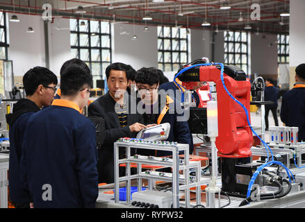 Chongqing, China. 14 Mär, 2019. Eine Lehrerin gibt einen Vortrag über Industrieroboter in der beruflichen Bildung Schule im yongchuan Bezirk von Chongqing, im Südwesten von China, 14. März 2019. Die lokalen Behörden bei der Verbesserung der beruflichen Bildung auf die Bedürfnisse des Arbeitsmarktes in den letzten Jahren gerecht zu werden. Credit: Wang Quanchao/Xinhua/Alamy leben Nachrichten Stockfoto