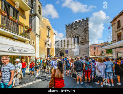 Eine Masse von Touristen versammelt sich vor der St. Catherine Kirche auf der Piazza Badia im Dorf an der Küste von Taormina, Italien Stockfoto