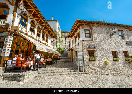 Ein Server braucht eine Bestellung aus einer Tabelle der Touristen in der Altstadt der mittelalterlichen Stadt Mostar, Bosnien und Herzegowina. Stockfoto