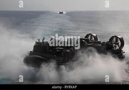 Golf von Oman (13. März 2019) A U.S. Navy Landing Craft, Luftpolster fährt die Wasp-Klasse amphibisches Schiff USS Kearsarge (LHD-3) mit Cargo ab der 22 Marine Expeditionary Unit während des Trainings. Kearsarge ist das Flaggschiff der Kearsarge amphibische Gruppe und bereit, mit der begonnen 22 Marine Expeditionary Unit, ist in die USA 5 Flotte Bereich der Maßnahmen zur Unterstützung der Marine im Einsatz für die Stabilität und Sicherheit in der Region zu gewährleisten und verbindet das Mittelmeer und den Pazifischen Raum durch den westlichen Indischen Ozean und drei strategischen Punkten ersticken. (U.S. Marin Stockfoto