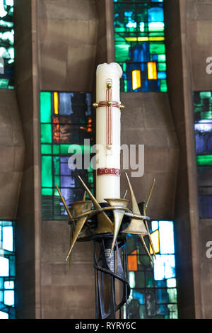 Kirche Stumpenkerze mit einem Kreuz vor der Buntglasfenster Stockfoto