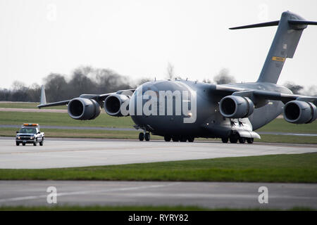 Eine C-17 Globemaster III von Charleston, S.C., Taxi in der Flight Line an RAF Fairford, England, 9. März 2019. Mehrere C-17 s erforderlich waren alle Unterstützung, die Ausrüstung, die benötigt wird, um in Europa für die Unterstützung der U.S. Strategic Command Bomber Task Force (BTF) zu liefern. (U.S. Air Force Foto von Flieger 1. Klasse Tessa B. Corrick) Stockfoto