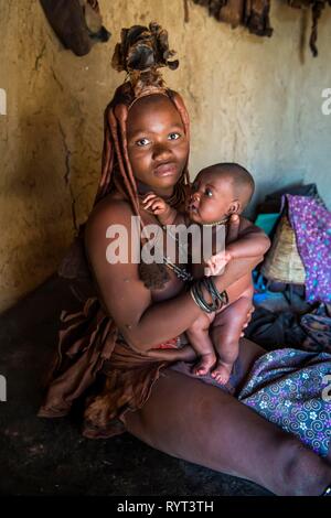 Frau Himba baby Holding, Kaokoveld, Namibia Stockfoto