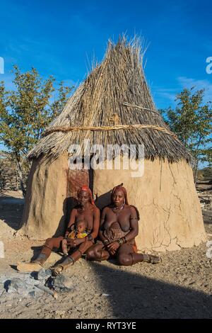 Himba Frauen vor ihrer Hütte, Kaokoveld, Namibia Stockfoto