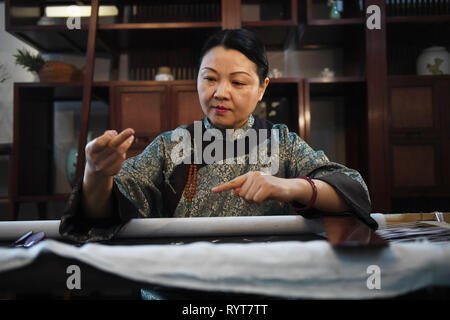 (190315) - NANJING, März 15, 2019 (Xinhua) - Fu Xianghong Stickt an Ihrem Workshop in Guangfu Stadt Wuzhong District von Suzhou in der ostchinesischen Provinz Jiangsu, am 14. März 2019. Fu Xianghong und ihre Tochter Fu Hanlu waren von einer langen Linie der Stickerei. Im Jahr 2015 Fu Xianghong war als Vertreter der Meister der Suzhou Stickerei, die als ein immaterieller Suzhou's Erbe aufgeführt wurde ernannt. Ihre Werke von einzigartigen Stil mit Zweckmäßigkeit und Kunstfertigkeit wurden jemals während der Fashion Week in Peking und Paris Fashion Week präsentiert. Ihre Tochter Fu Hanlu zeigten auch großes Interesse an Stickerei Stockfoto