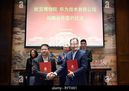 (190315) - Peking, 15. März 2019 (Xinhua) - der stellvertretende Direktor des Palastmuseums Feng Naien (L, vorne) schüttelt Hände mit Hua Qiang, Vice President von Huawei China, nachdem sie ein Abkommen in Palace Museum in Peking, der Hauptstadt von China, 15. März 2019 unterzeichnet. Der Palast Museum wird mit Huawei zusammen, um 5G Netzwerke anwenden, weitere Förderung der Digitalisierung und intelligenten Aufbau des Museums. (Xinhua / Jin Liangkuai) Stockfoto