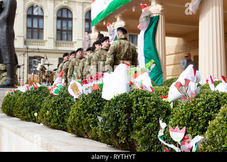 Sopron, Ungarn. 15 Mär, 2019. Die Soldaten der "honvéd Hagyományőrző Egyesület" an Petőfi Square, Sopron, Ungarn. Ungarische Symbole, Fahnen, tulip Formen von Kindern stehen im Vordergrund. Credit: Wahavi/Alamy leben Nachrichten Stockfoto