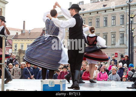 Sopron, Ungarn. 15 Mär, 2019. Paare der Volkstänzer durchführen, traditionelle Ungarische Tänze auf der Bühne Petőfi Square, Sopron, Ungarn. Leute im Publikum tragen die traditionelle tricolor Kokarde. Credit: Wahavi/Alamy leben Nachrichten Stockfoto