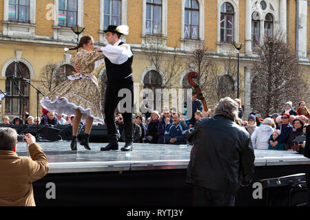 Sopron, Ungarn. 15 Mär, 2019. Ein paar der Volkstänzer führt Traditionelle Ungarische Tänze auf der Bühne Petőfi Square, Sopron, Ungarn. Feder Gras (stipa) ist in den Kop aufgeklebt, wie es in den alten Zeiten wurde verwendet. Credit: Wahavi/Alamy leben Nachrichten Stockfoto