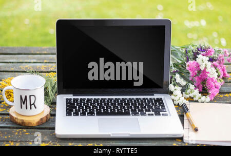 Laptop auf den Tisch mit Blumen Stockfoto