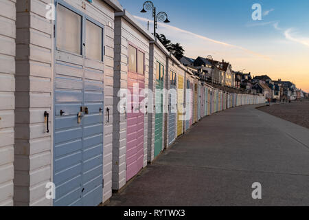 Eine beeindruckende Reihe von bunten Badekabinen auf Lyme Regis, Schuß am Meer bei Sonnenaufgang Stockfoto