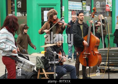 Gruppe von straßenmusikern in London Street mit Kontrabass, Geige und Schlagzeug Stockfoto