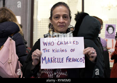 Eine Frau gesehen, die ein Plakat, das liest, befohlen, das Töten von Marielle Franco?, während der gebetswache. Die Demonstranten versammelten sich vor der Brasilianischen Botschaft in London das Leben und das Vermächtnis des Brasilianischen Aktivist Marielle Franco, war ein ausgesprochener Kritiker der Polizeibrutalität und außergerichtliche Tötungen gegen Favela Bewohnerinnen zu ehren. Franco wurde ermordet wegen ihrer politischen Aktivitäten zusammen mit ihrem Fahrer Anderson Gomes am 14. März in Rio de Janeiro, Brasilien 2018. Während der gebetswache Redner sprachen die Assistenten und beanspruchten Gerechtigkeit und forderten das Ende der Straflosigkeit in Francos Verbrechen. Stockfoto