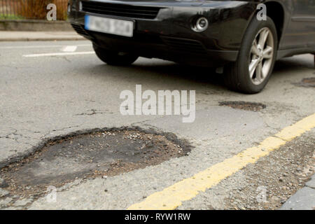 Schlaglöcher auf einer Straße mit Wohnhäusern. Wandsworth, London. 25.03.2010. Stockfoto