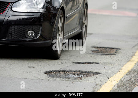 Schlaglöcher auf einer Straße mit Wohnhäusern. Wandsworth, London. 25.03.2010. Stockfoto