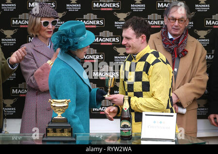 Die Princess Royal präsentiert Jockey Paul Townend (rechts) mit der Trophäe, nachdem er das magners Cheltenham Gold Cup Chase auf Al Boum Foto während Gold Cup Tag der 2019 Cheltenham Festival in Cheltenham Racecourse. Stockfoto