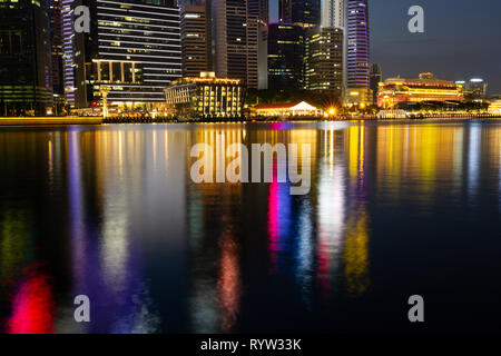 Downtown Singapur während der Blauen Stunde mit der Stadt Lite und in der Marina Bay unter widerspiegelt. Stockfoto