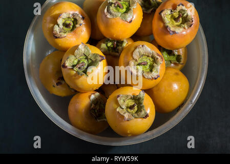 Gewaschen nasse Kaki in einer Schüssel auf den Tisch, schließen. Stockfoto
