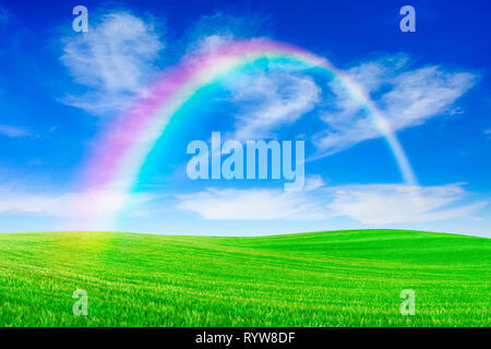 Idyllische Landschaft, Regenbogen über grünen Feldern, im Hintergrund, blauer Himmel und weiße Wolken Stockfoto