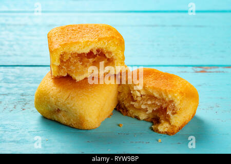 Seitenansicht Ananas Kuchen mit einem Schnitt auf blauem Hintergrund Stockfoto