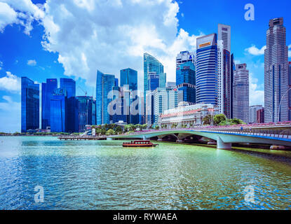 Singapur, Singapur - 1. März 2016: Fullerton Hotel Gebäude an der Marina Bay in Singapur und Fähre im Jubilee Bridge. Skyline mit Wolkenkratzern o Stockfoto