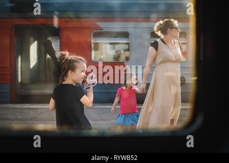 Moskau Russland - Juli 27., 2017. Blick aus dem Zugfenster. Familie von Mutter und zwei Töchtern, von denen einer Mutter hält an der Hand, im Hintergrund der Stockfoto