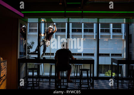 Abgebildet ist jemand mit einem Handy im Restaurant an der Millennials Shibuya Kapselhotel. Stockfoto