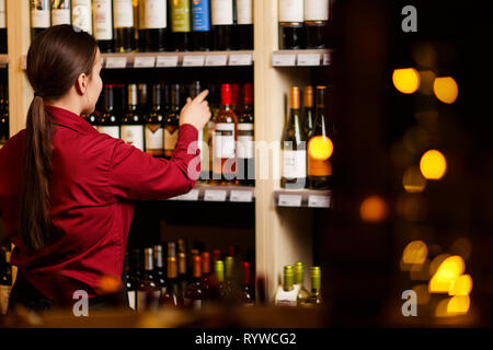 Bild von der Rückseite der jungen Frau im Wein Shop Stockfoto