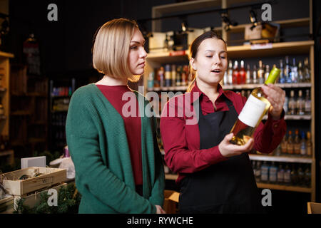 Bild von jungen Frauen mit einer Flasche Wein in der Hand Stockfoto