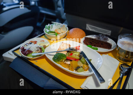 Essen an Bord der Business Class Flugzeug auf dem Tisch. Tablett mit Essen im Flugzeug. Fach von Lebensmitteln auf der Ebene, die Reise in der Business Class. Vorbereitet Stockfoto