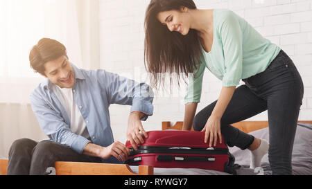 Paar versuchen valise zu schließen, packen Koffer Stockfoto