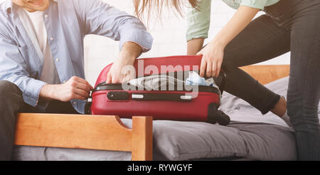 Packen Koffer. Paar versuchen valise zu schließen. Stockfoto