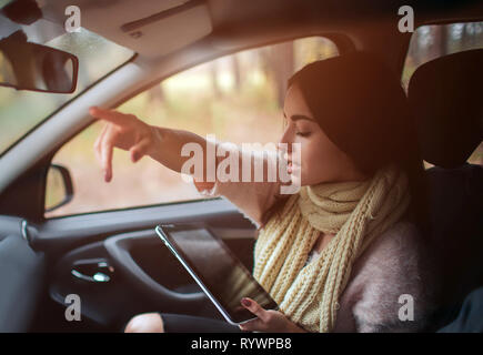 Frauen, die mit Hilfe von GPS auf Tablet compter im Auto in den Urlaub zu navigieren. Stockfoto