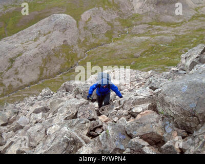 Einsame männliche Klettern Felsen und Geröll auf der Schottischen Berge Corbett-stac Beag Ruadh in Wester Ross, North West Highlands, Schottland, Großbritannien. Stockfoto