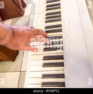 Süße Musik mit den Tasten mit den Fingern der Hand des alten Musiker gespielt Stockfoto