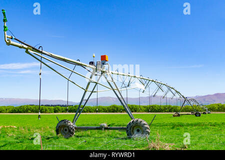 Große Drehmittelpunkt Bewässerungssystem läuft auf einem Bauernhof in Canterbury, Neuseeland. Lange bewegliche Booms der Wasserversorgung Anlagen erstrecken sich von f Stockfoto