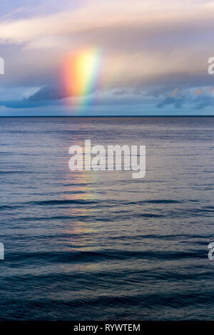 Aus den Wolken Regenbogen auf dem Ozean Horizont erscheint Stockfoto