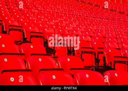 Zeilen von nummerierten faltbar glänzendes rot Kunststoff Platz für Fans auf den Terrassen der wichtigsten an der Liverpool Football Club Anfield Road Stadium, Lancashire, UK. Stockfoto