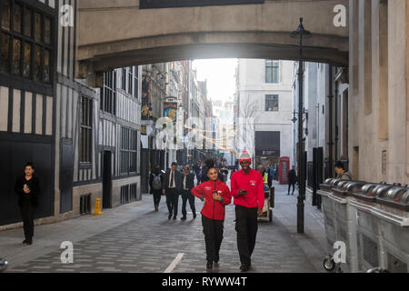 LONDON - Februar 15, 2019: Ein junger Mann mit einem Mädchen im roten Trainingsanzug entlang der Fußgängerzone in der Nähe der Liberty store Stockfoto