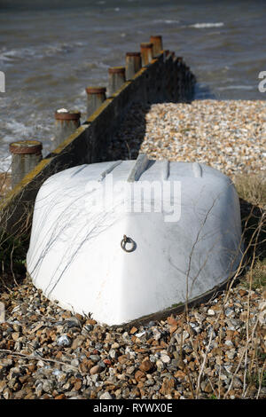 Umgedrehten beiboot am Strand in Whitstable, Kent, England. Stockfoto